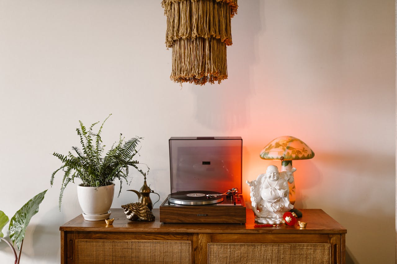 Stylish home decor featuring a Buddha statue, vintage turntable, and plants.